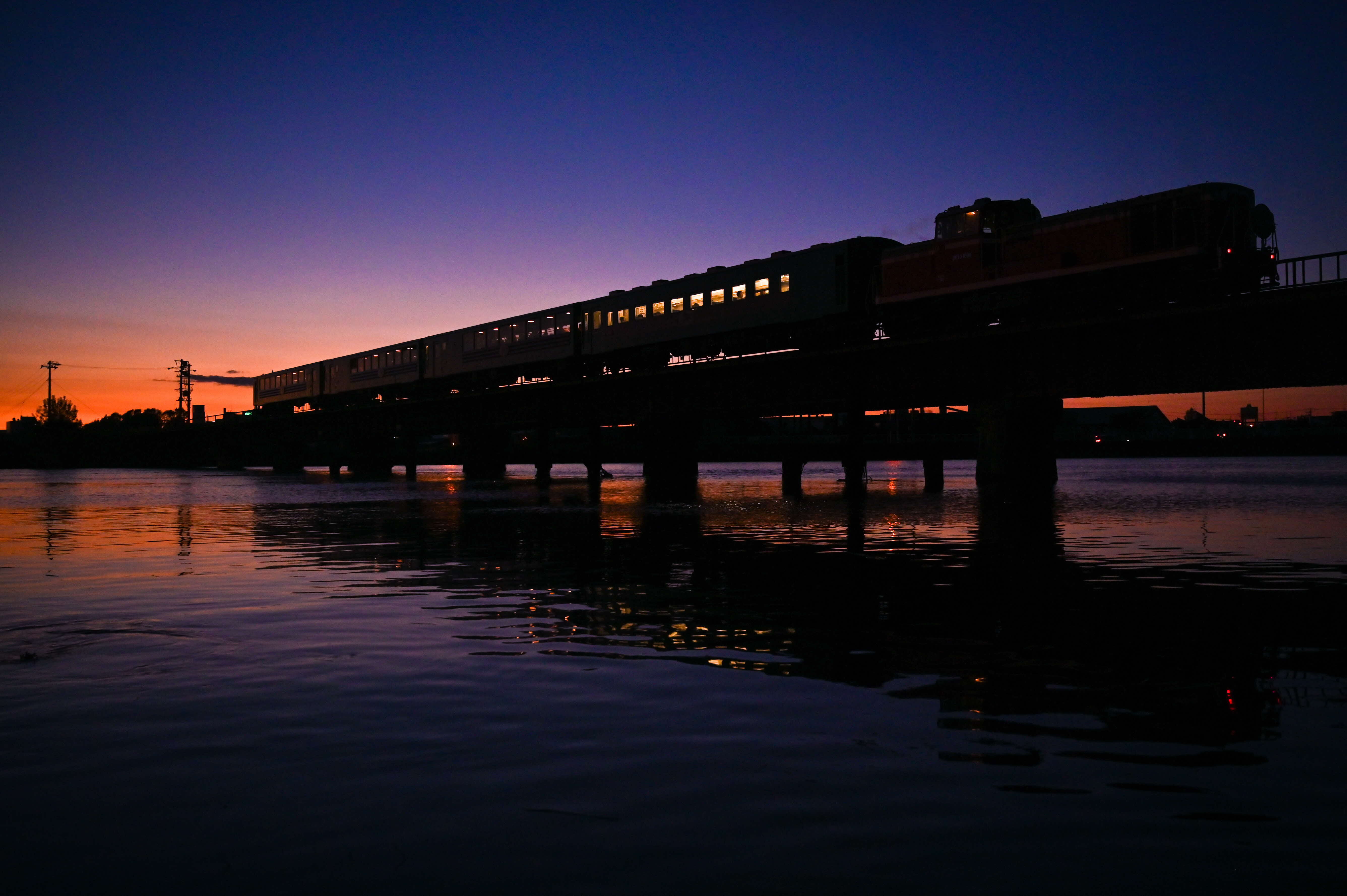 橋の上のノロッコ号と夕日がうつる作品