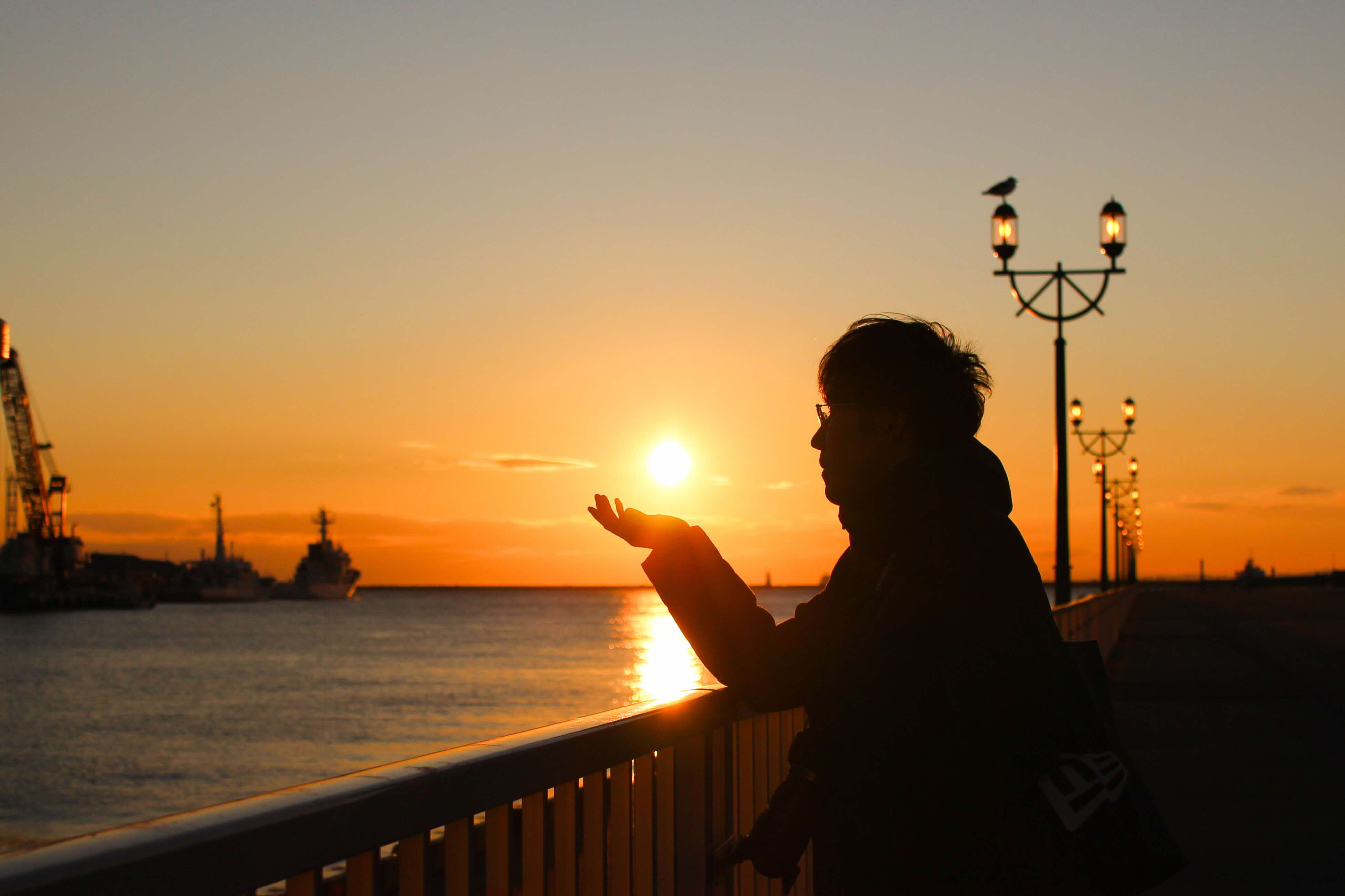 夕日を手に載せているかのように撮影された作品